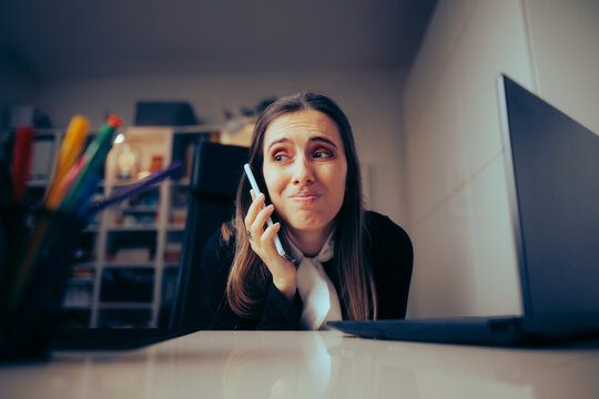 Stressed Businesswoman Speaking on the Phone Feeling Overwhelmed. Unhappy office worker feeling frustrated by mean phone call
