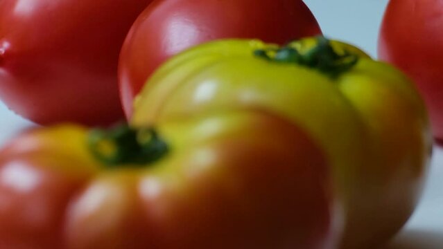 Closeup shot of Tomatoes in different colors and soft light from the left side and white background