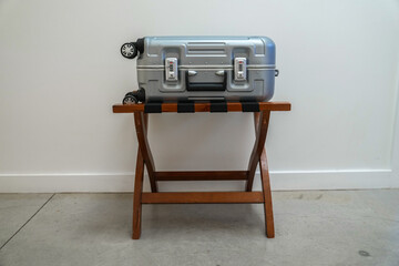Suitcase on wooden luggage rack on concrete industrial floor hotel