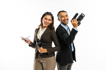 a male journalist standing with a camera at his hand beside a female journalist in brown blazer