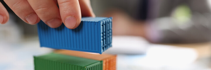 Stack of cargo containers on financial report papers and blurred business man.