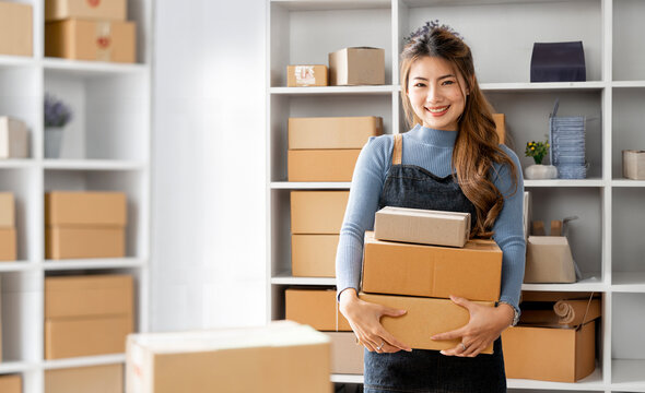 Startup small business entrepreneur or freelance Asian woman holding parcel box, Young success Asian woman with her online marketing packaging box and delivery