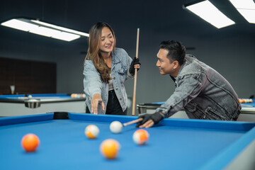 couple of pool players looking each other while playing billiard together at billiard studio