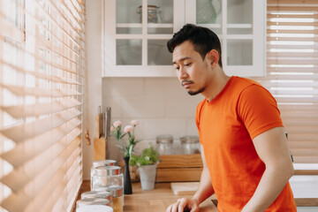 Asian man calm in the kitchen in the morning prepare his easy breakfast.