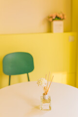 Tables, chairs and aromatherapy in the cozy warm yellow room