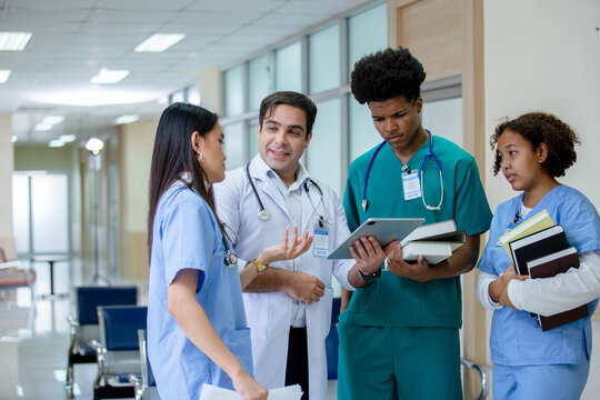 Teacher Doctor Man And Group Of Medical Student Standing Looking Work In Tablet. Education And Learning Medical Concept.