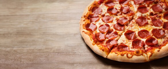 Wide banner of a handmade pepperoni pizza on a rustic wooden table, copy space, generative ai