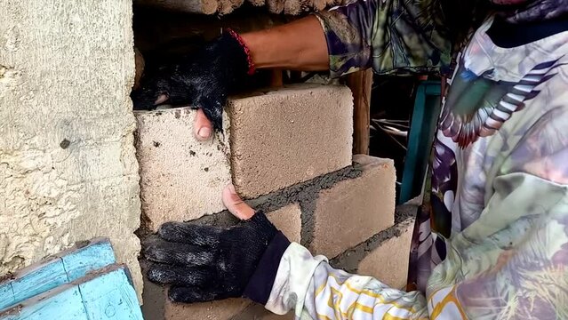 A Builder Who Is Installing And Tidying Up The Arrangement Of Bricks