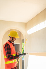 Young engineer in charge of building construction checking his tablet device