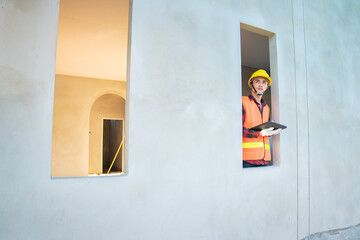 Young engineer in charge of building construction checking his tablet device
