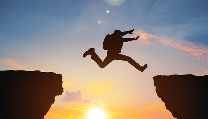 man jumping over impossible or possible over cliff on sunset background,business concept idea