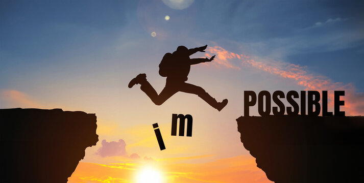 success concept ,silhouette man jumping over impossible and possible wording on hill with sunset