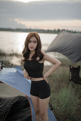 Asian woman on Tent Camping with backpack relaxing  enjoying coffee Sunrise river lake view....