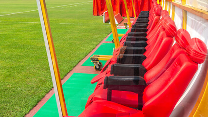Red bench or seat or chair of staff coach or substitution player in the stadium of football or soccer.