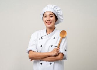 Young beautiful asian woman chef in uniform holding ladle utensils cooking in the kitchen various...