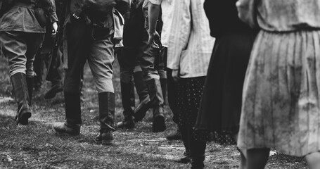 Group Of Re-enactors Dressed As Soviet Russian Soldiers Escort Civilians. Soviet Russian Soldiers...
