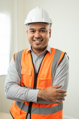 Vertical of Confident engineer handsome man at modern home building construction. Architect with white safety helmet at site. Real Estate building under construction. Foreman senior worker