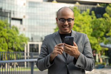 Senior manager business man in suit with cell phone at the buildings downtown. Confident man using...