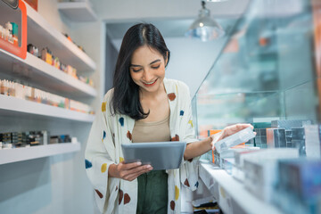 female seller checking the vape mods inside the display table using the digital tablet