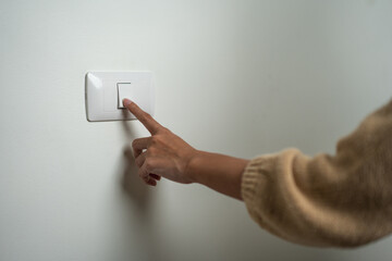 Earth Hour Close up woman finger turn off or on the light to saving electrical energy. Finger...