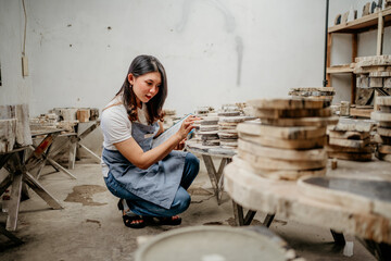 young businesswoman checks a pile of craft stones while squatting at a stone craft warehouse