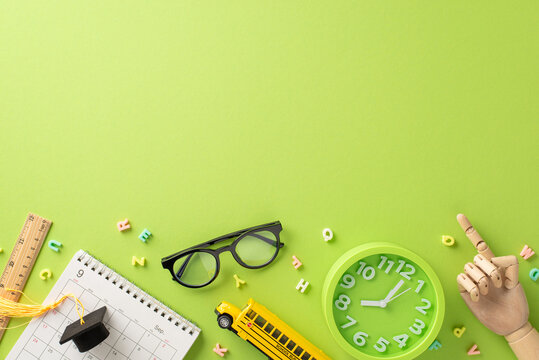 Explore realm of education through this compelling above view picture of calendar, mini graduation cap and school items on isolated light green background. Customizable copyspace for text or promotion - Powered by Adobe