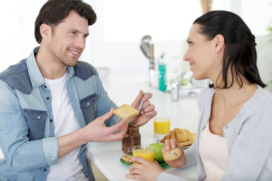 complicit couple having breakfast at home