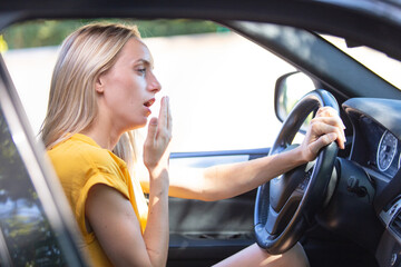 tired woman yawning inside car