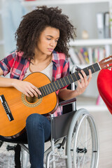 woman in wheelchair playing guitar