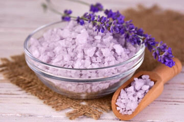 Lavender bath salt in a glass bowl and fresh lavender flowers.
