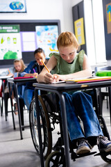 Caucasian schoolgirl in wheelchair with diverse schoolchildren in school classroom
