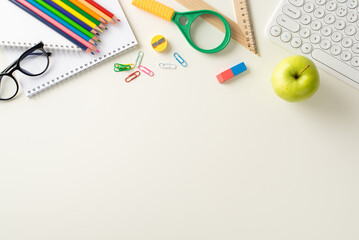 Explore the possibilities of remote learning with this top-down snapshot displaying a keyboard, albums, office supplies on white background. Utilize the copy-space for text or advertisements