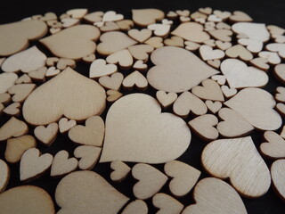 Obraz premium Wooden hearts on a black background as a postcard for the holidays