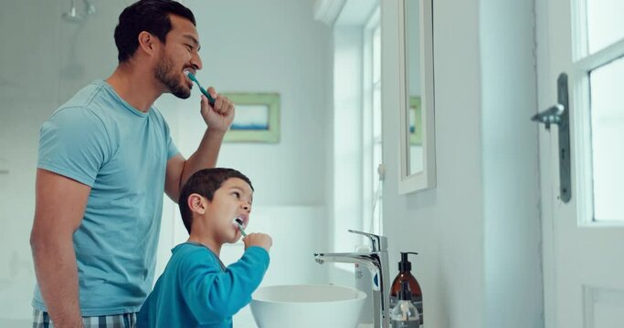 Father, child and brushing teeth in family home bathroom while learning or teaching dental hygiene. A man and kid with toothbrush and toothpaste for health, cleaning mouth and wellness at mirror