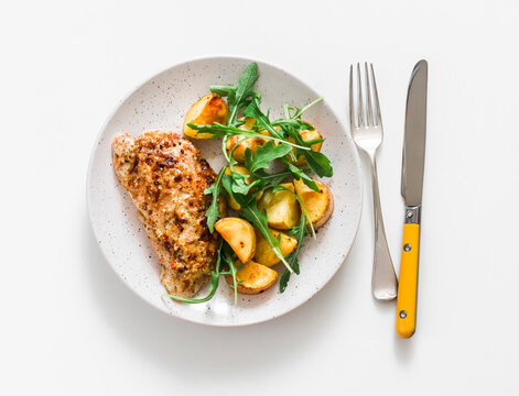 Mustard, greek yogurt marinade baked turkey  and new potatoes, arugula salad on a light background, top view