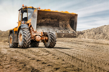 Wheel front loader or bulldozer at a construction site in a quarry. Powerful modern equipment for...