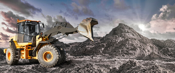 Wheel front loader or bulldozer at a construction site in a quarry. Powerful modern equipment for earthworks. Construction site. Rental of construction equipment. © Anoo