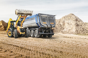Obraz premium Modern construction machinery at a construction site in a quarry. Powerful modern equipment for earthworks. Rental of construction equipment. Excavator, dump truck, bulldozer, loader.