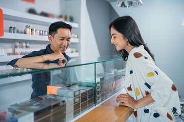 Obraz premium male shopkeeper explaining the variants of the vape mod to the female customer