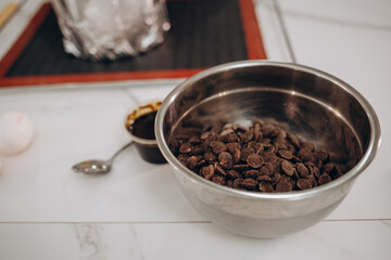 dark chocolate chunks in wooden bowl, on oak table