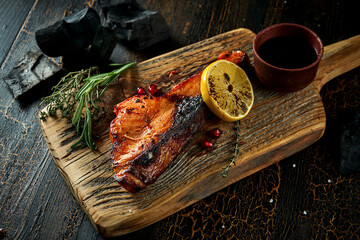 Grileld salmon steak on wooden board. Delicious seafood