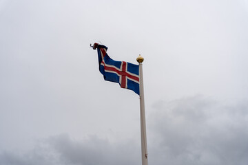 Icelandic flag waving against cloudy sky