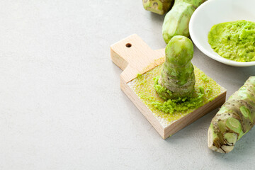 grated fresh wasabi and wasabi roots on a kitchen slab.