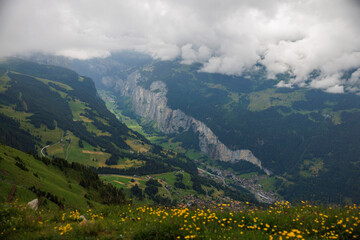 Naklejka na ściany i meble view from Männlichen through clouds into Lauterbrunnen valley