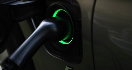 Electric charger flashes green-blue in vehicle charging connector. Connectors and types of chargers for electric vehicles concept