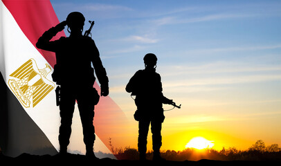 Fototapeta na wymiar Silhouettes of soldiers against the sunset with Egypt flag. Background for National Holidays. Concept - Armed Forces