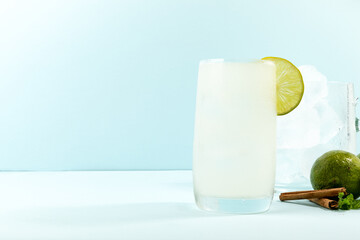 Summer refreshing lemonade drink or alcoholic cocktail on bright cyan background