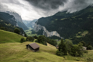 Fototapeta na wymiar view from Wengen with farm shed through clouds into Lauterbrunnen valley