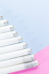 Energy Saving Concepts. Line of Used Outdated Fluorescent Lamps Over Colorful Background.
