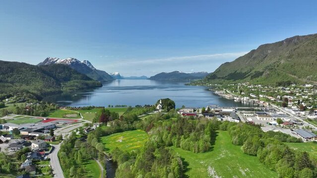 Sjoholt and Orskog along road E39 underway to Alesund in western Norway - Rising summer aerial while moving slowly ahead over lush green landscape and looking at fjord Orskogvika